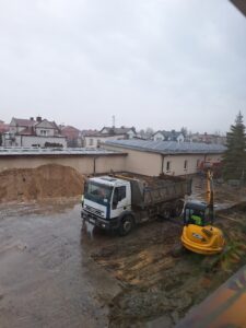 Plac budowy BCU, na placu maszyny budowlane pracownicy wykonujące prace ziemne