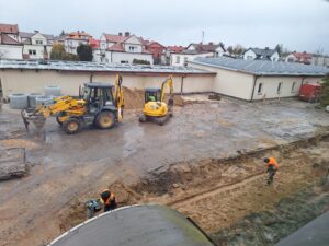 Plac budowy BCU, na placu maszyny budowlane pracownicy wykonujące prace ziemne
