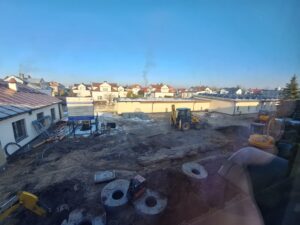 Plac budowy BCU, na placu maszyny budowlane pracownicy wykonujące prace ziemne