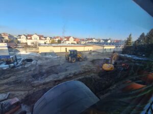 Plac budowy BCU, na placu maszyny budowlane pracownicy wykonujące prace ziemne