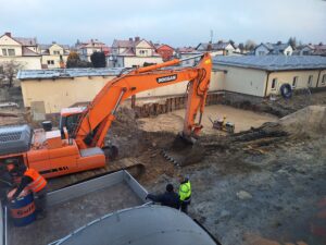 Plac budowy BCU, na placu maszyny budowlane pracownicy wykonujące prace ziemne