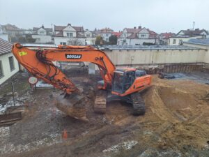 Plac budowy BCU, na placu maszyny budowlane pracownicy wykonujące prace ziemne