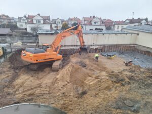 Plac budowy BCU, na placu maszyny budowlane pracownicy wykonujące prace ziemne