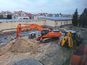 Plac budowy BCU, na placu maszyny budowlane pracownicy wykonujące prace ziemne