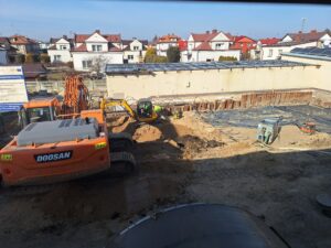 Plac budowy BCU, na placu maszyny budowlane pracownicy wykonujące prace ziemne