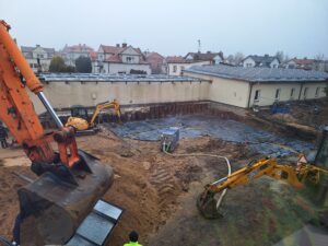 Plac budowy BCU, na placu maszyny budowlane pracownicy wykonujące prace ziemne