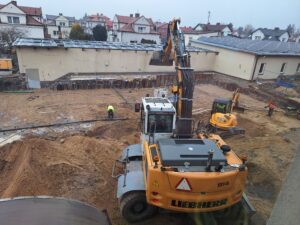 Plac budowy BCU, na placu maszyny budowlane pracownicy wykonujące prace ziemne