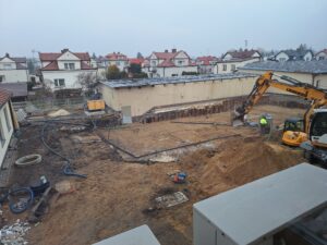 Plac budowy BCU, na placu maszyny budowlane pracownicy wykonujące prace ziemne