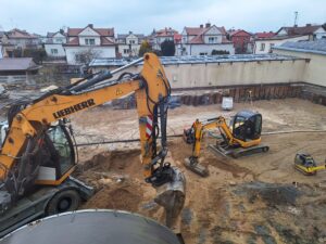 Plac budowy BCU, na placu maszyny budowlane pracownicy wykonujące prace ziemne