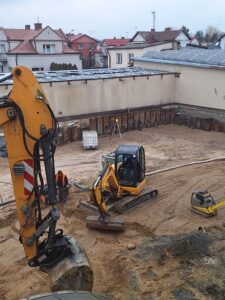 Plac budowy BCU, na placu maszyny budowlane pracownicy wykonujące prace ziemne