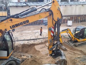 Plac budowy BCU, na placu maszyny budowlane pracownicy wykonujące prace ziemne