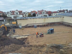Plac budowy BCU, na placu maszyny budowlane pracownicy wykonujące prace ziemne