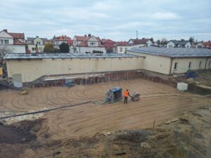 Plac budowy BCU, na placu maszyny budowlane pracownicy wykonujące prace ziemne