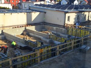 Plac budowy BCU. Pracujące maszyny pracownicy, Widać fundamenty budynku