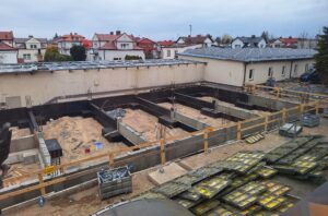 Plac budowy BCU. Pracujące maszyny pracownicy, Widać fundamenty budynku