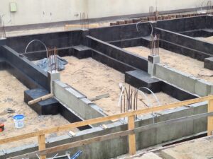 Plac budowy BCU. Pracujące maszyny pracownicy, Widać fundamenty budynku