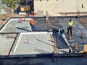 Plac budowy BCU. Pracujące maszyny pracownicy, Widać kolejny etap prac budowlanych (zalewanie filarów)