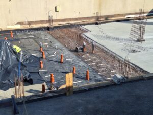 Plac budowy BCU. Pracujące maszyny pracownicy, Widać kolejny etap prac budowlanych (zalewanie filarów)