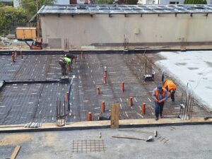 Plac budowy BCU. Pracujące maszyny pracownicy, Widać kolejny etap prac budowlanych (zalewanie filarów)