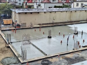 Plac budowy BCU. Pracujące maszyny pracownicy, Widać kolejny etap prac budowlanych (zalewanie filarów)