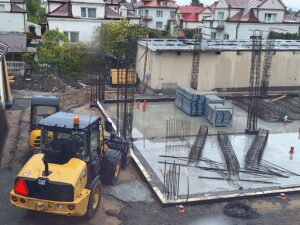 Plac budowy BCU. Pracujące maszyny pracownicy, Widać kolejny etap prac budowlanych (zalewanie filarów)