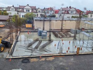 Plac budowy BCU. Pracujące maszyny pracownicy, Widać kolejny etap prac budowlanych (zalewanie filarów)