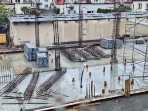 Plac budowy BCU. Pracujące maszyny pracownicy, Widać kolejny etap prac budowlanych (zalewanie filarów)