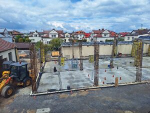 Plac budowy BCU. Pracujące maszyny pracownicy, Widać kolejny etap prac budowlanych (zalewanie filarów)