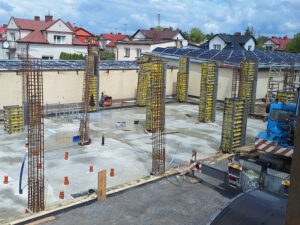 Plac budowy BCU. Pracujące maszyny pracownicy, Widać kolejny etap prac budowlanych (zalewanie filarów)