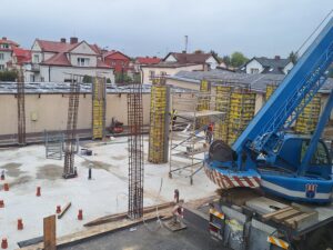 Plac budowy BCU. Pracujące maszyny pracownicy, Widać kolejny etap prac budowlanych (zalewanie filarów)