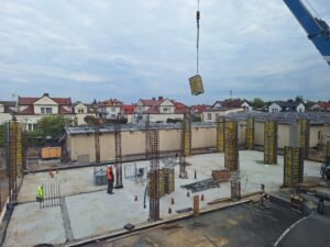 Plac budowy BCU. Pracujące maszyny pracownicy, Widać kolejny etap prac budowlanych (zalewanie filarów)