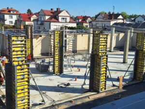 Plac budowy BCU. Pracujące maszyny pracownicy, Widać kolejny etap prac budowlanych (zalewanie filarów)