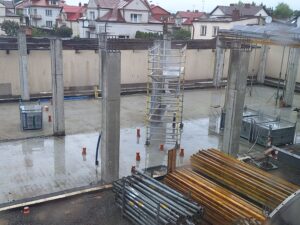 Plac budowy BCU. Pracujące maszyny pracownicy, Widać kolejny etap prac budowlanych (zalewanie filarów)