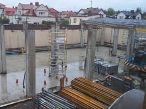 Plac budowy BCU. Pracujące maszyny pracownicy, Widać kolejny etap prac budowlanych (zalewanie filarów)