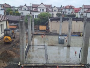 Plac budowy BCU. Pracujące maszyny pracownicy, Widać kolejny etap prac budowlanych (zalewanie filarów)