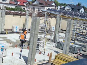 Plac budowy BCU. Pracujące maszyny pracownicy, Widać kolejny etap prac budowlanych (zalewanie filarów)