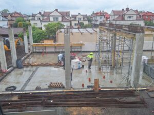 Plac budowy BCU. Pracujące maszyny pracownicy, Widać kolejny etap prac budowlanych (zalewanie filarów)