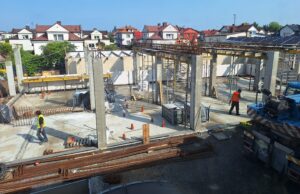 Plac budowy BCU. Pracujące maszyny pracownicy, Widać kolejny etap prac budowlanych (zalewanie filarów)