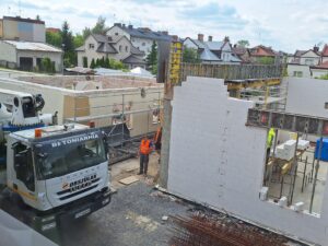 Plac budowy BCU. Widać budowę ścian budynku. Rozbiórka dachu starej spawalni