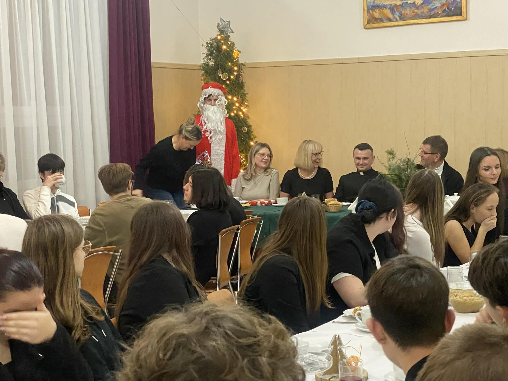 Św. Mikołaj rozdaje prezenty uczestnikom Wigilii w internacie.