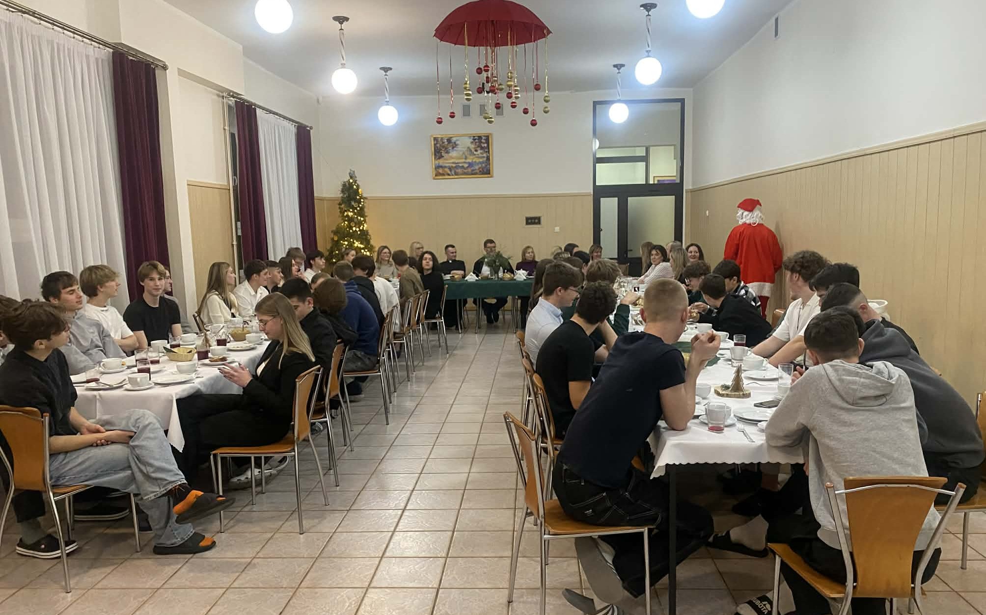 Św. Mikołaj rozdaje prezenty uczestnikom Wigilii w internacie.